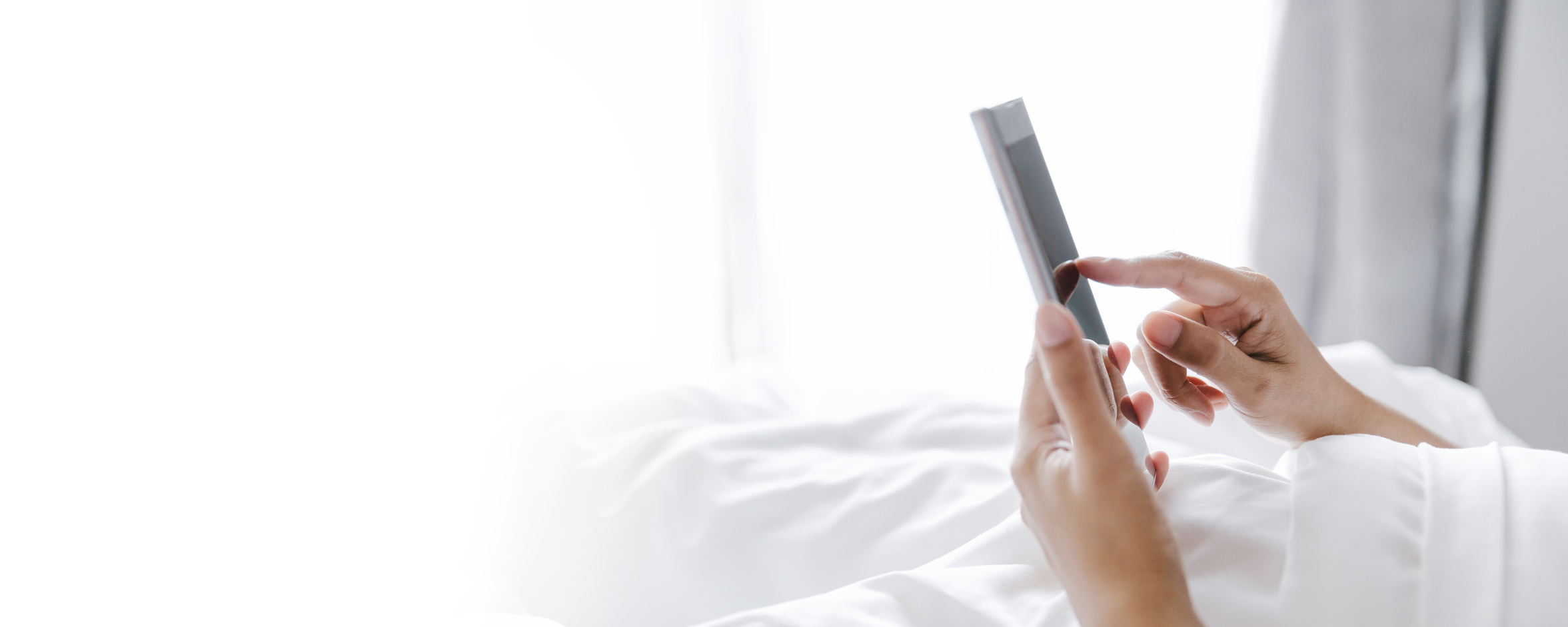 Woman with mobile phone on bed